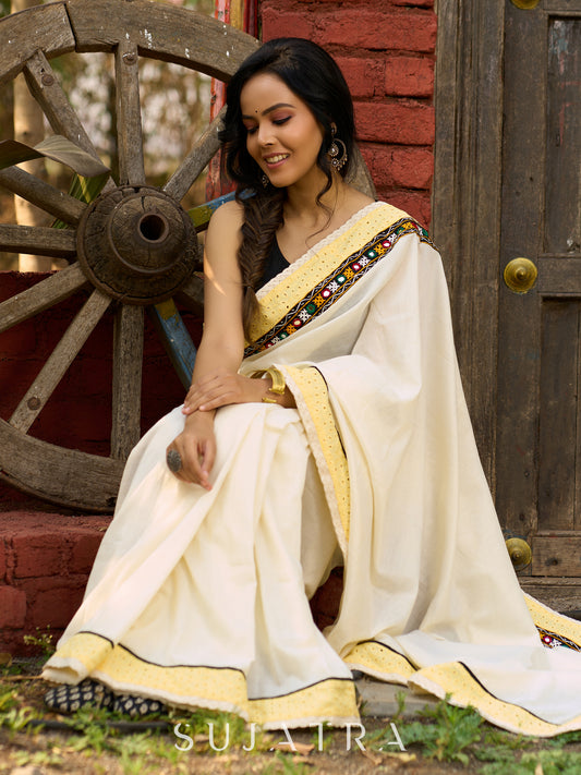Exclusive off white mul saree with yellow hakoba border paired with Kutch mirror work border
