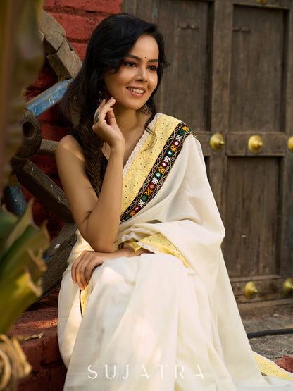 Exclusive off white mul saree with yellow hakoba border paired with Kutch mirror work border