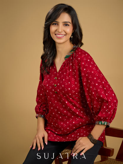 Red rayon bandhani top beautifully combined with classic ikat collar.
