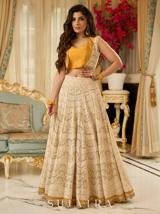 A chic off-white Hakoba Lehenga with intricate gold embroidery accented by a bold, saffron yellow blouse - Gold embroidered hakoba Shrug Optional