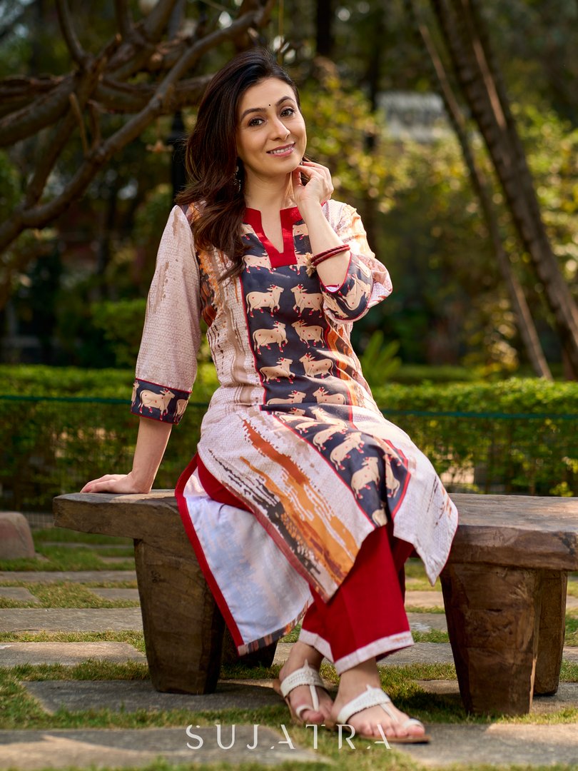 Artisanal off-white kurta showcasing Pichwai-inspired cow artwork highlighted with classic red tones