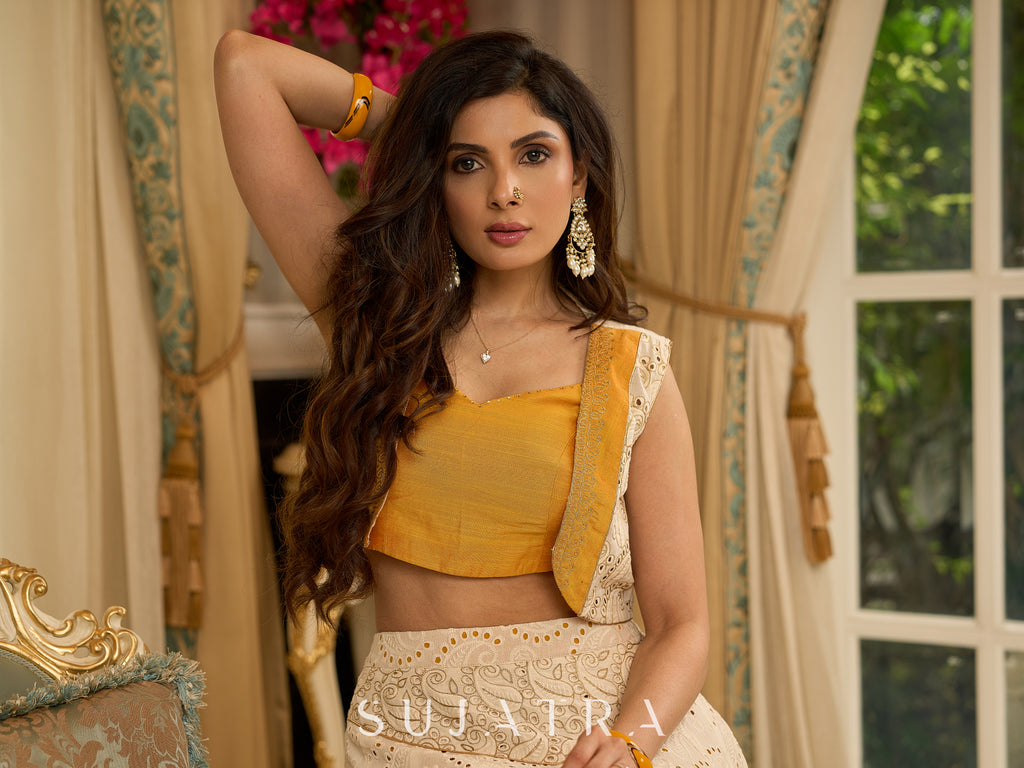 A chic off-white Hakoba Lehenga with intricate gold embroidery accented by a bold, saffron yellow blouse - Gold embroidered hakoba Shrug Optional