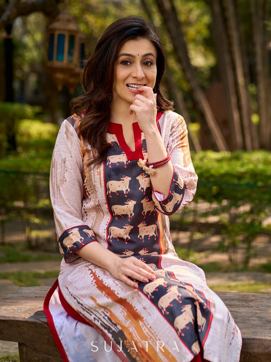 Artisanal off-white kurta showcasing Pichwai-inspired cow artwork highlighted with classic red tones