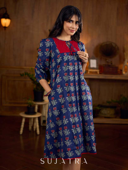 Royal blue Jaipur-printed dress featuring red rose motifs, a pintuck neck patch with red accents, and balloon 3/4th sleeves, creating a graceful silhouette with a blend of artisanal charm and contemporary elegance.