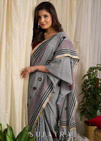 Graceful grey cotton saree adorned with intricate block prints and captivating mantra details
