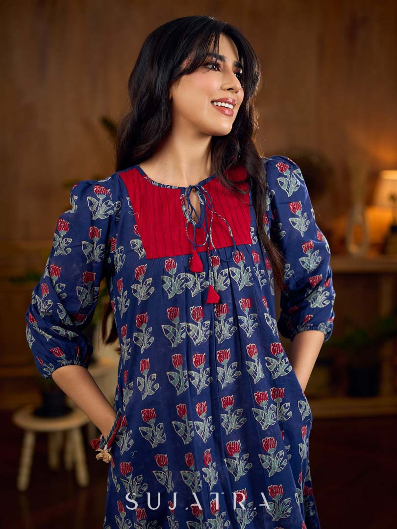 Royal blue Jaipur-printed dress featuring red rose motifs, a pintuck neck patch with red accents, and balloon 3/4th sleeves, creating a graceful silhouette with a blend of artisanal charm and contemporary elegance.