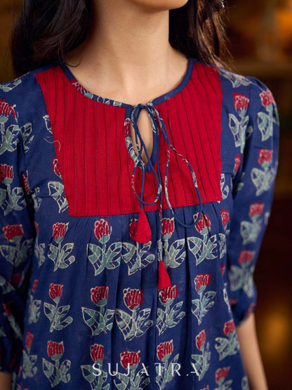 Royal blue Jaipur-printed dress featuring red rose motifs, a pintuck neck patch with red accents, and balloon 3/4th sleeves, creating a graceful silhouette with a blend of artisanal charm and contemporary elegance.