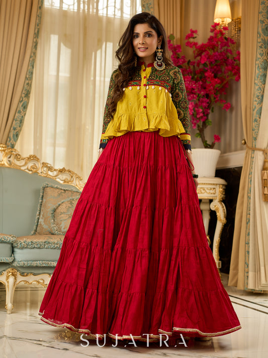 Red tiered Jamdani lehenga with a striking green Ajrakh and mustard jamdani choli featuring intricate mirror work & shell tassels .