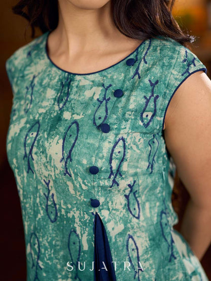 Indigo printed dress featuring playful fish motifs, designed in a gathered side-panel silhouette with contrast navy blue accents, creating a fluid, contemporary look with refined artisanal charm.