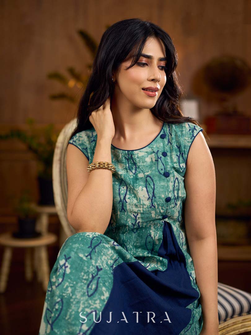 Indigo printed dress featuring playful fish motifs, designed in a gathered side-panel silhouette with contrast navy blue accents, creating a fluid, contemporary look with refined artisanal charm.