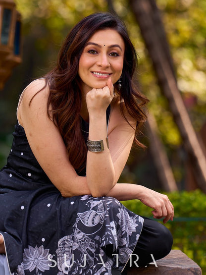 Modern black kurta blending playful polka dots and intricate Madhubani art, finished with a sleek halter neck