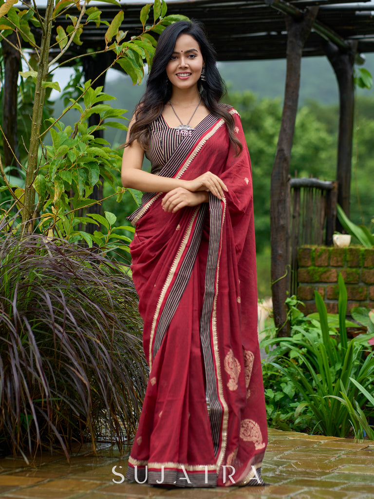 Artisanal maroon Jamdani saree elevated with zari-bordered detailing