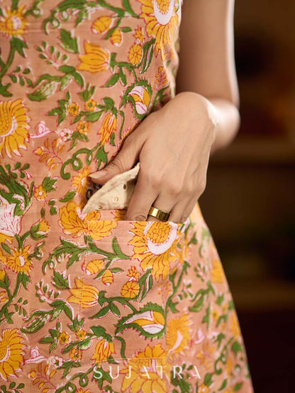 Summery mustard and peach floral sleeveless dress featuring a boat neckline and Hakoba pocket detailing, finished with soft off-white accents for a breezy, cheerful silhouette perfect for warm days.