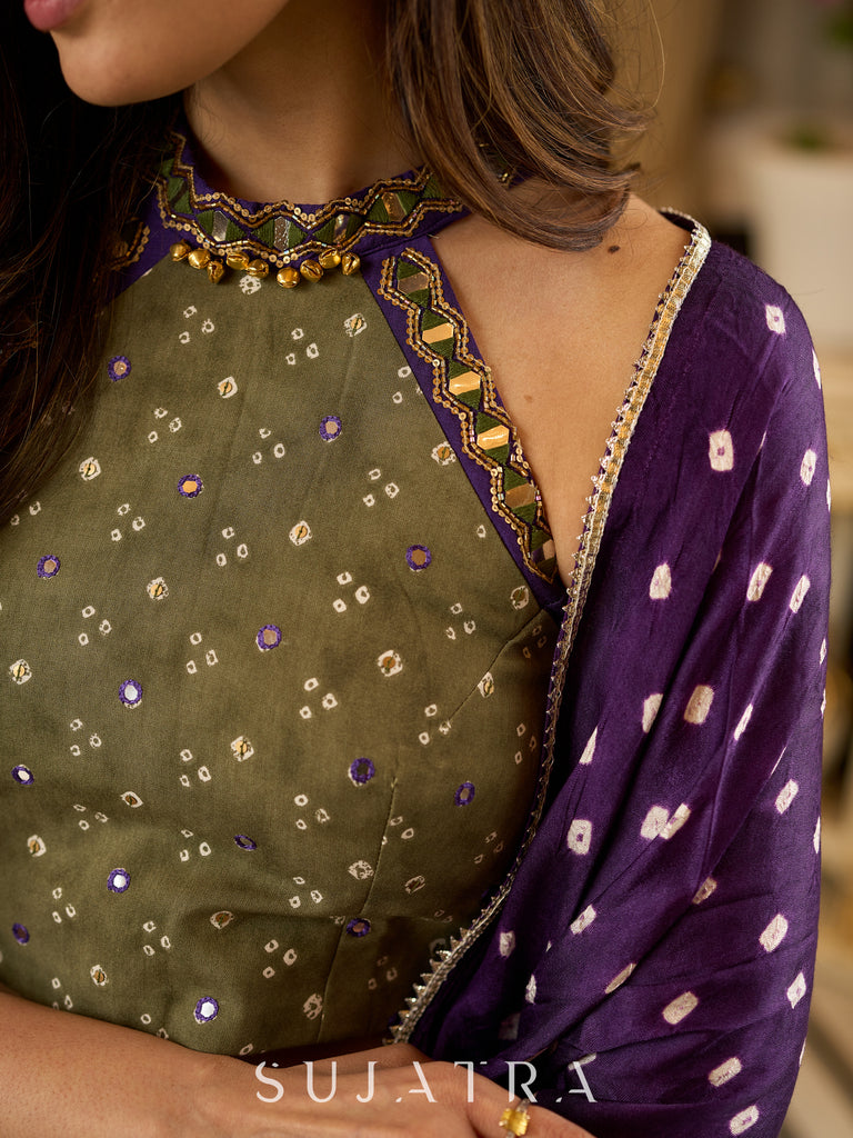 Vibrant Mehendi green and purple bandhani lehenga paired with a mirror work halter neck choli and matching dupatta.