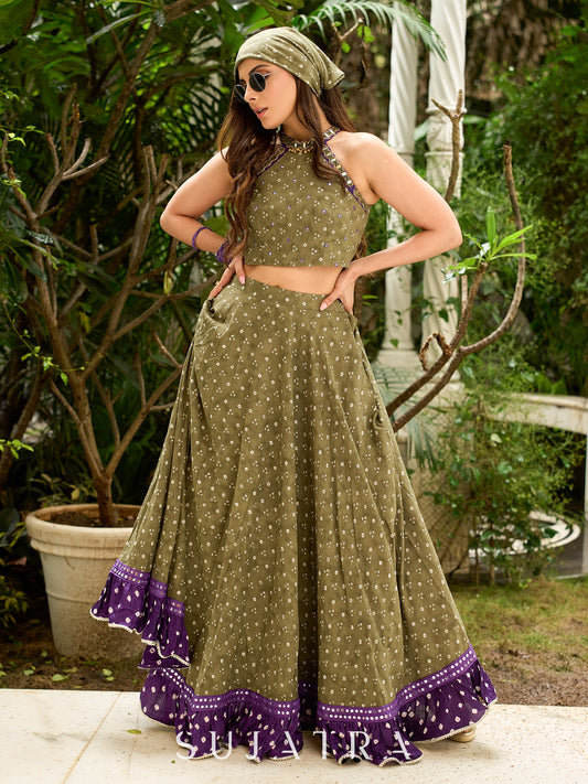 Vibrant Mehendi green and purple bandhani lehenga paired with a mirror work halter neck choli and matching dupatta.