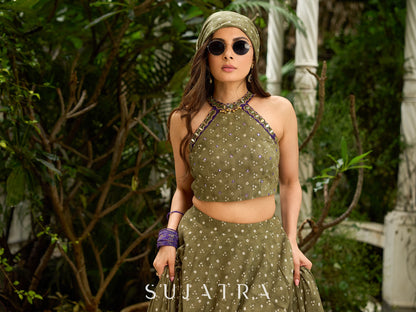 Vibrant Mehendi green and purple bandhani lehenga paired with a mirror work halter neck choli and matching dupatta.