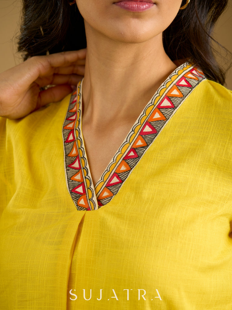 Traditional madhubani hand painting enhances this bright yellow cotton top.