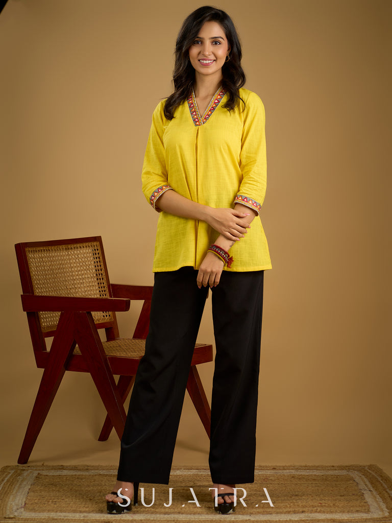 Traditional madhubani hand painting enhances this bright yellow cotton top.