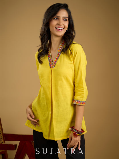 Traditional madhubani hand painting enhances this bright yellow cotton top.