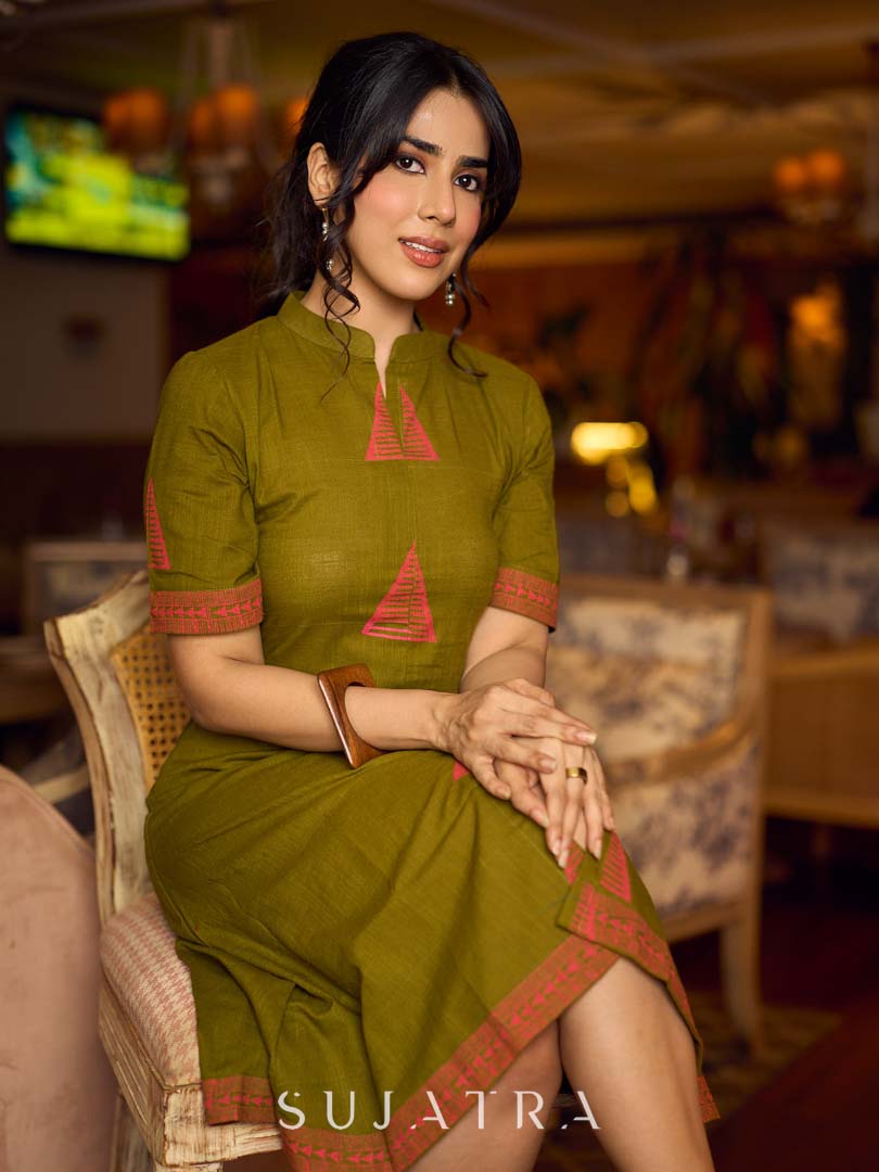 Gorgeous olive dress with pink abstract triangle hand block prints placed at the centre, sleeves, and back, featuring a mandarin collar and half sleeves for a refined, contemporary look.