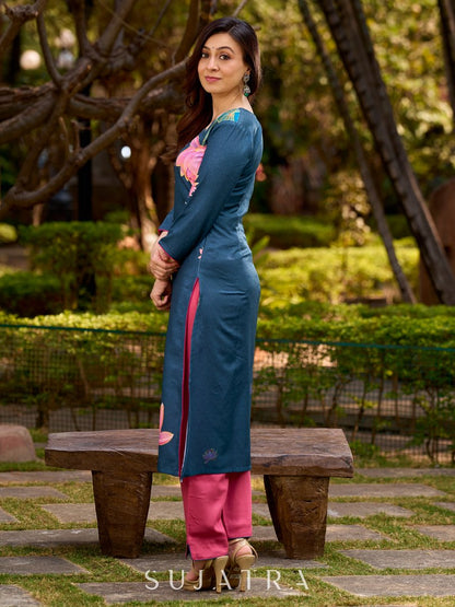 Graceful teal kurta with delicate pink lotus printing, subtle pink accents, and a statement patch above the neckline.