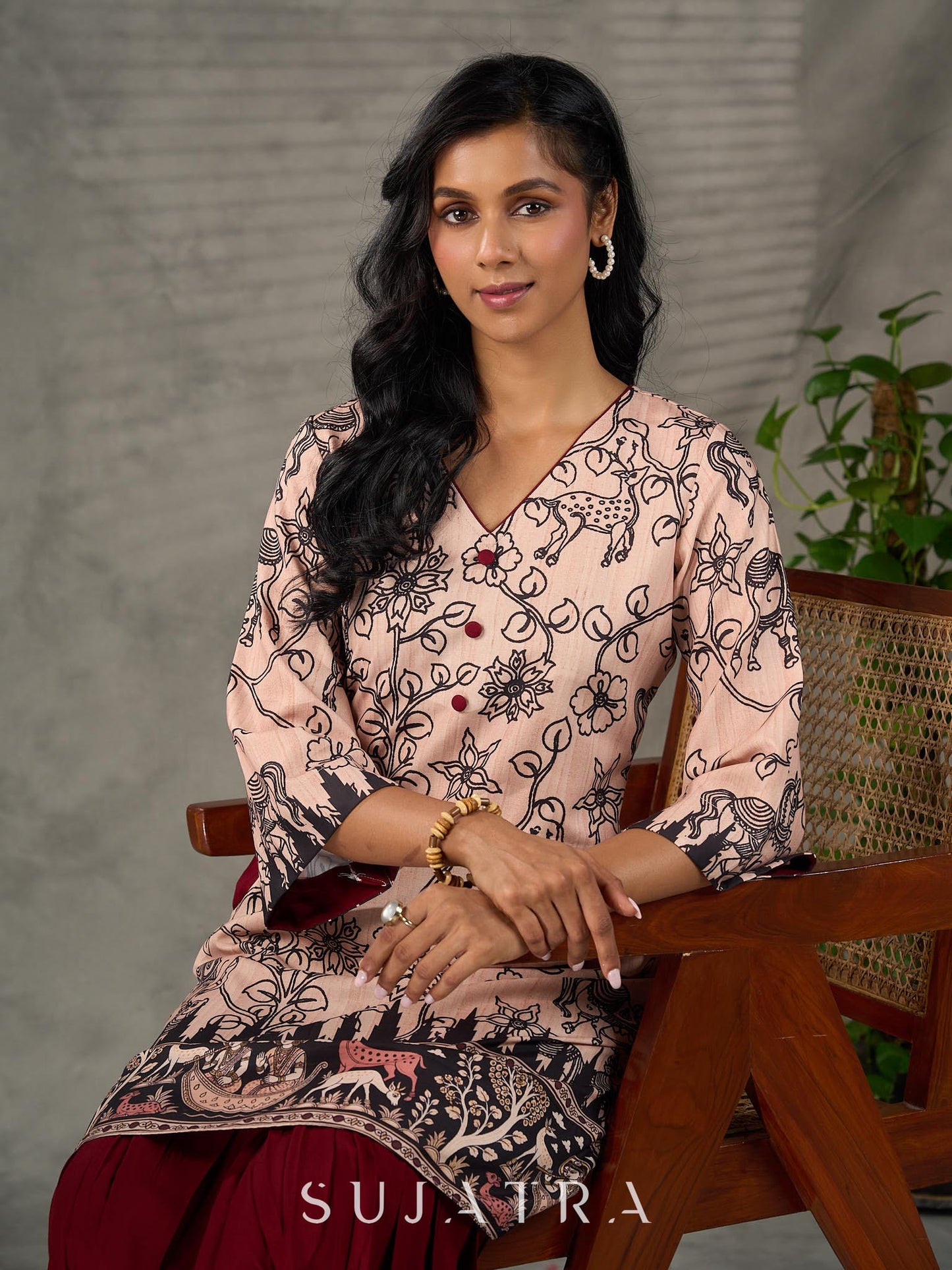 Beige traditional printed dress with rich maroon accents.