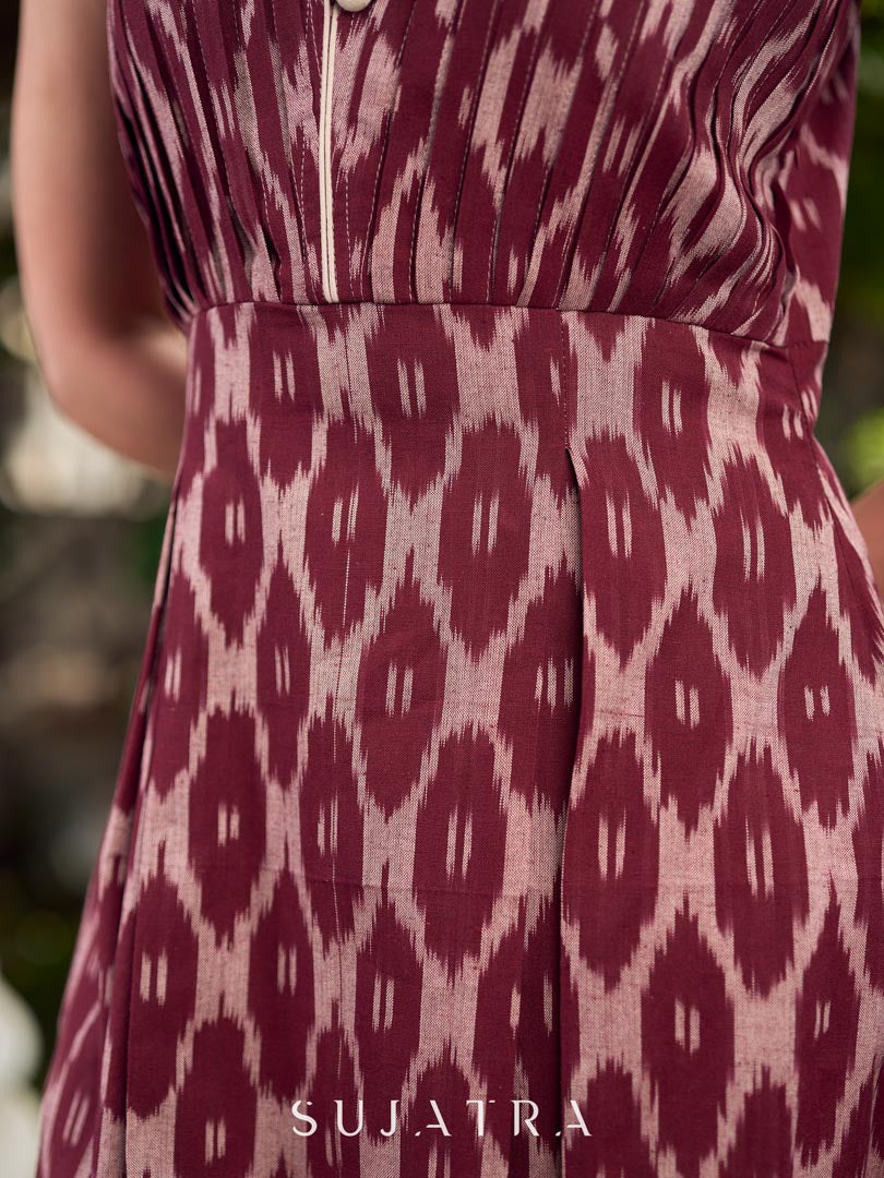 Statement maroon Ikat sleeveless dress elevated with pintuck detailing through the bodice and box pleats beyond the darts for a soft, flowing finish.