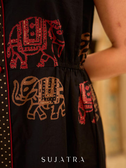 Statement black sleeveless shirt dress showcasing elephant-inspired prints and polka dots, highlighted with maroon accents.