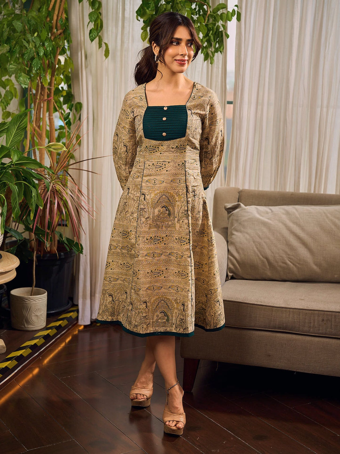 Artisanal beige Madhubani dress featuring intricate motifs, a contrasting green yoke, and refined accents.