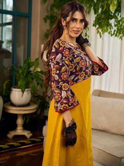 Mustard Kalamkari dress with an asymmetrical yoke and puffed sleeves.