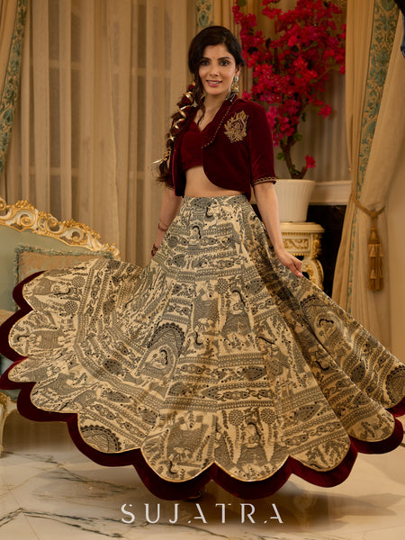 Madhubani print lehenga with a scalloped hem, paired with a rich maroon velvet blouse - Short Jacket with elegant brooch style embroidery Optional