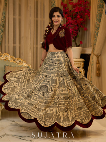 Madhubani print lehenga with a scalloped hem, paired with a rich maroon velvet blouse - Short Jacket with elegant brooch style embroidery Optional