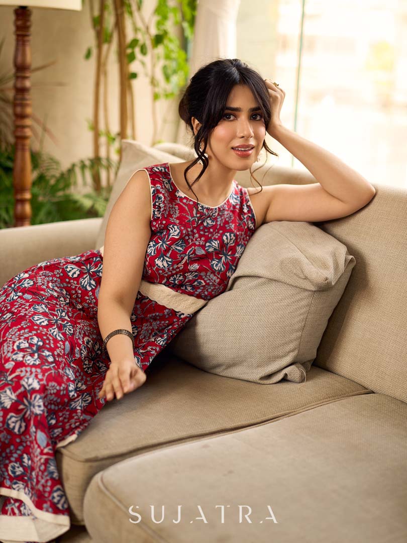 Red Gulmohar floral-printed sleeveless summer dress featuring off-white accents and scalloped lace detailing at the waist, creating a breezy, feminine silhouette perfect for warm, sunlit days.