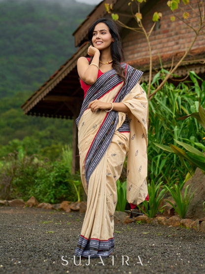 Beige cotton saree enriched with traditional Ikat border and Jamdani accents