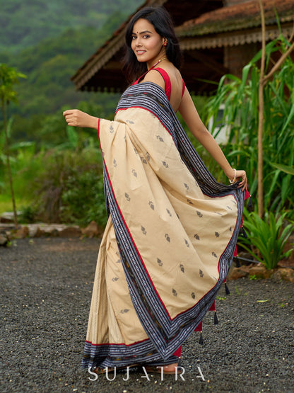 Beige cotton saree enriched with traditional Ikat border and Jamdani accents