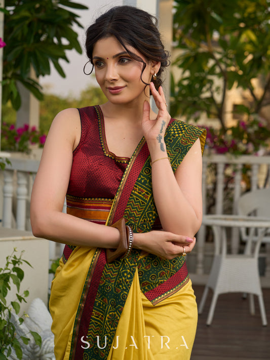 Vibrant yellow silk mix saree with hand block printed Ajrakh border