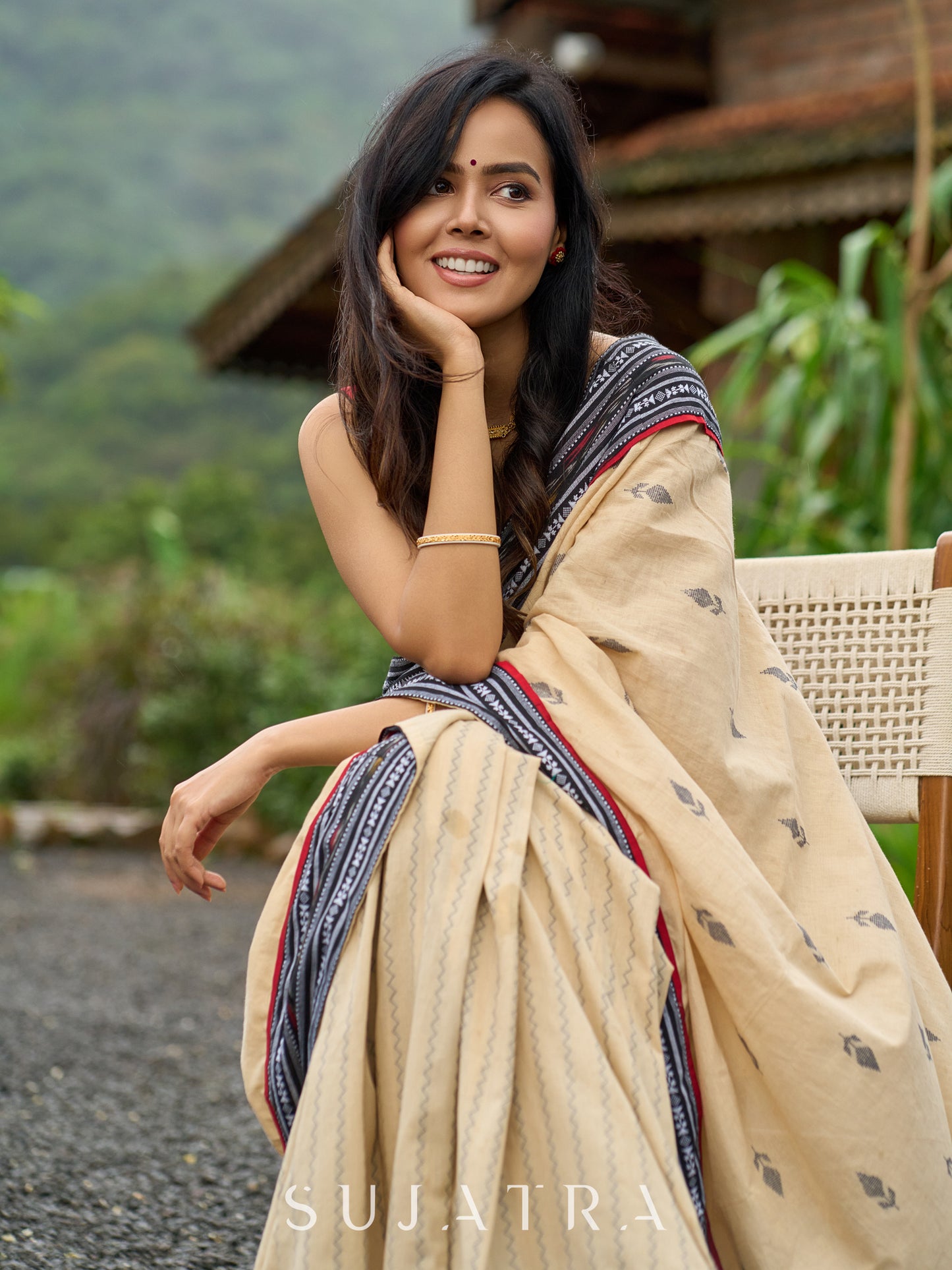 Beige cotton saree enriched with traditional Ikat border and Jamdani accents