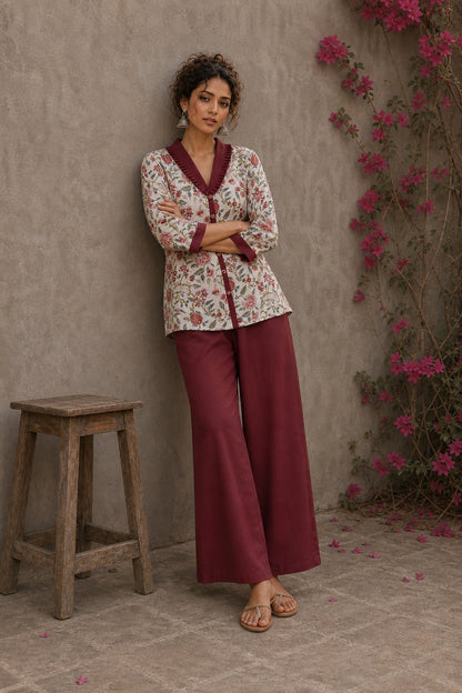 Soft white floral cotton top finished with maroon cuffs, pleated collar, and delicate feminine elegance.