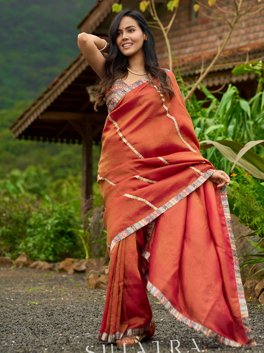 Luxury burnt orange tissue saree adorned with shimmering zari highlights