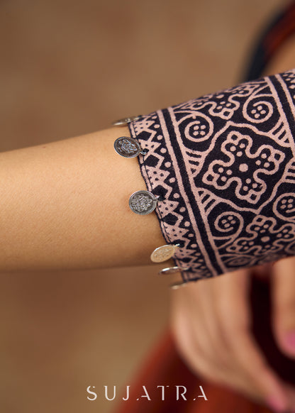 Striking half and half Ajrakh blouse combining maroon & black hues elevated by intricate coin work .