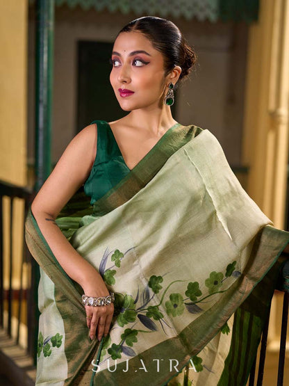 Muted Green Tussar Silk Saree with Delicate Floral Artwork and Classic Border