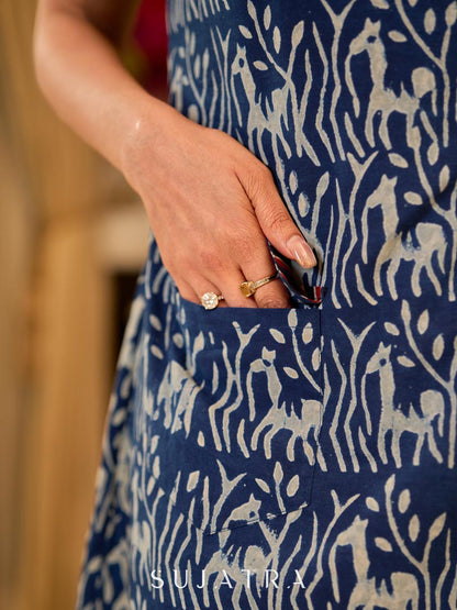 Chic indigo wrap-style dress featuring animal-inspired motifs with a striped belt and refined accents.