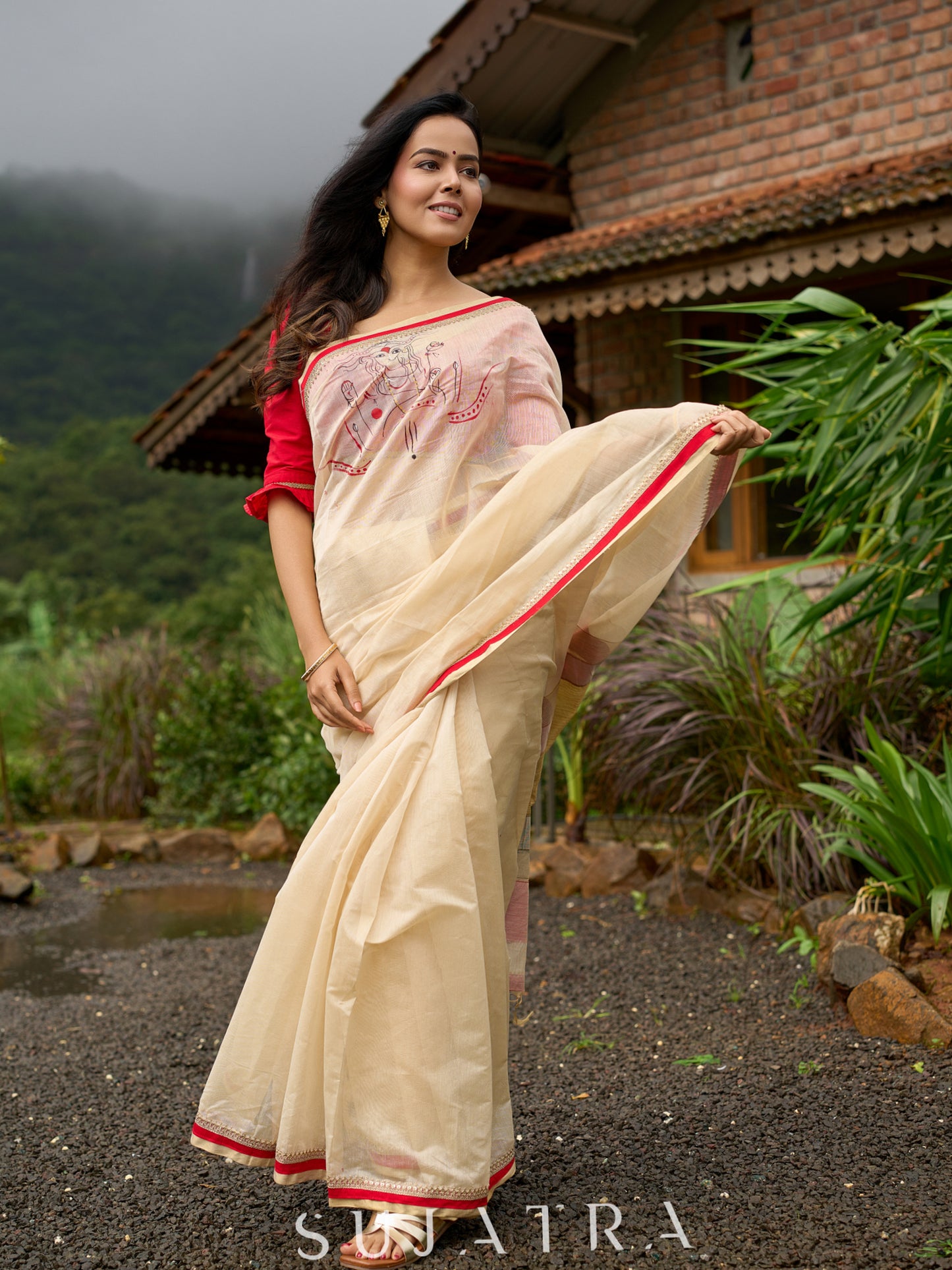 Elegant cream chanderi saree with subtle red border, featuring hand-painted Durga art