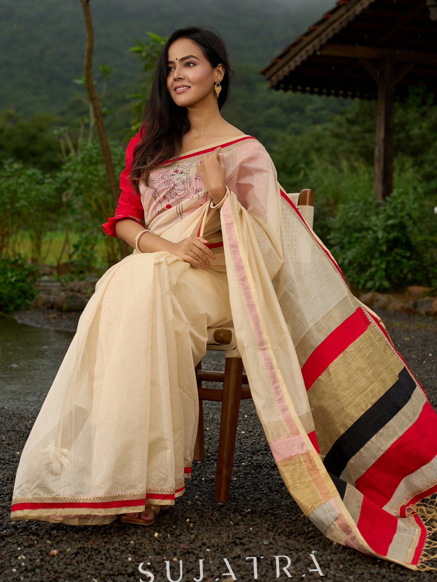Elegant cream chanderi saree with subtle red border, featuring hand-painted Durga art