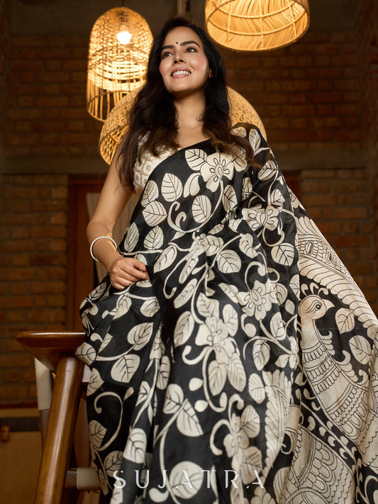 Artisanal black silk saree featuring intricate hand-drawn Kalamkari style motifs