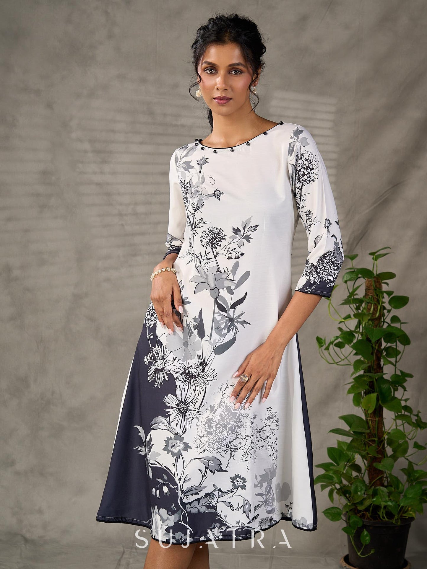 White and black floral dress with pearl embellishments and black accents.