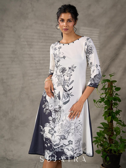 White and black floral dress with pearl embellishments and black accents.