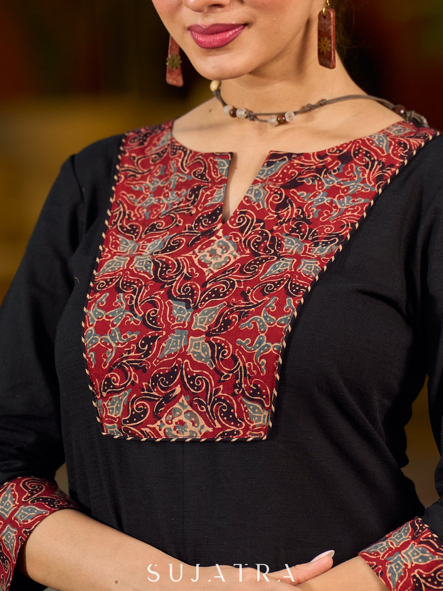 elegant black cotton kurta with beautifully crafted ajrakh panel and subtle stripe piping accents