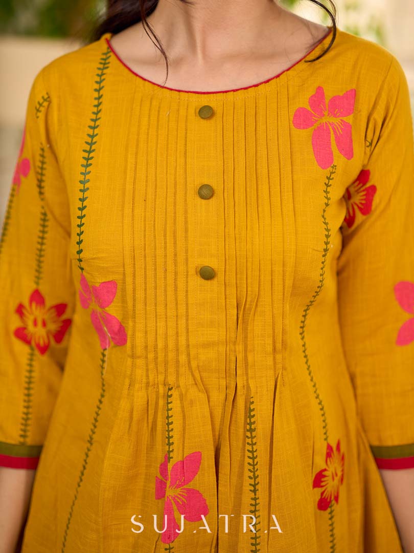 Mustard block printed pintuck dress with hand block red and pink vine floral motifs, accented with red and olive details for a rich, elegant look.