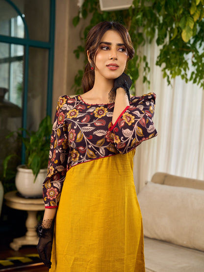 Mustard Kalamkari dress with an asymmetrical yoke and puffed sleeves.
